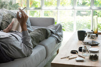Man relaxing on couch smoking marijuana