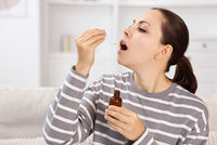 Young woman taking CBD tincture