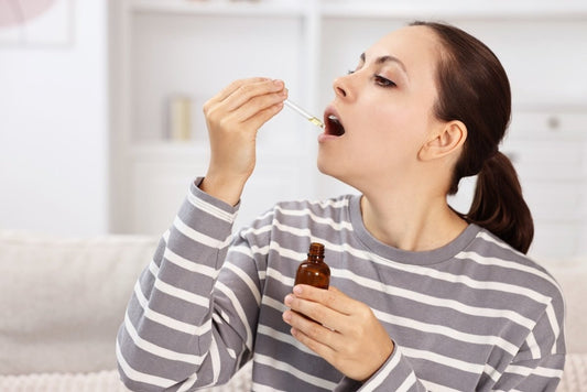 Young woman taking CBD tincture